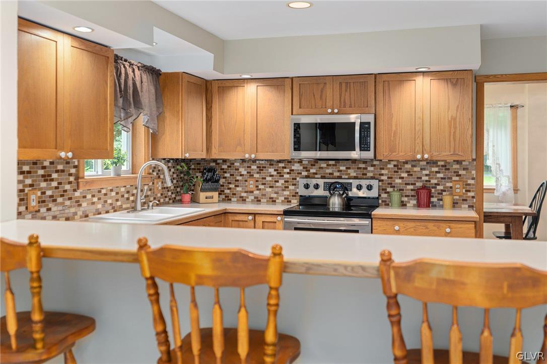3220 Winding Road Kintnersville, PA 18930 - Photo 30 of 50 a kitchen with stainless steel appliances wooden cabinets a sink and a microwave