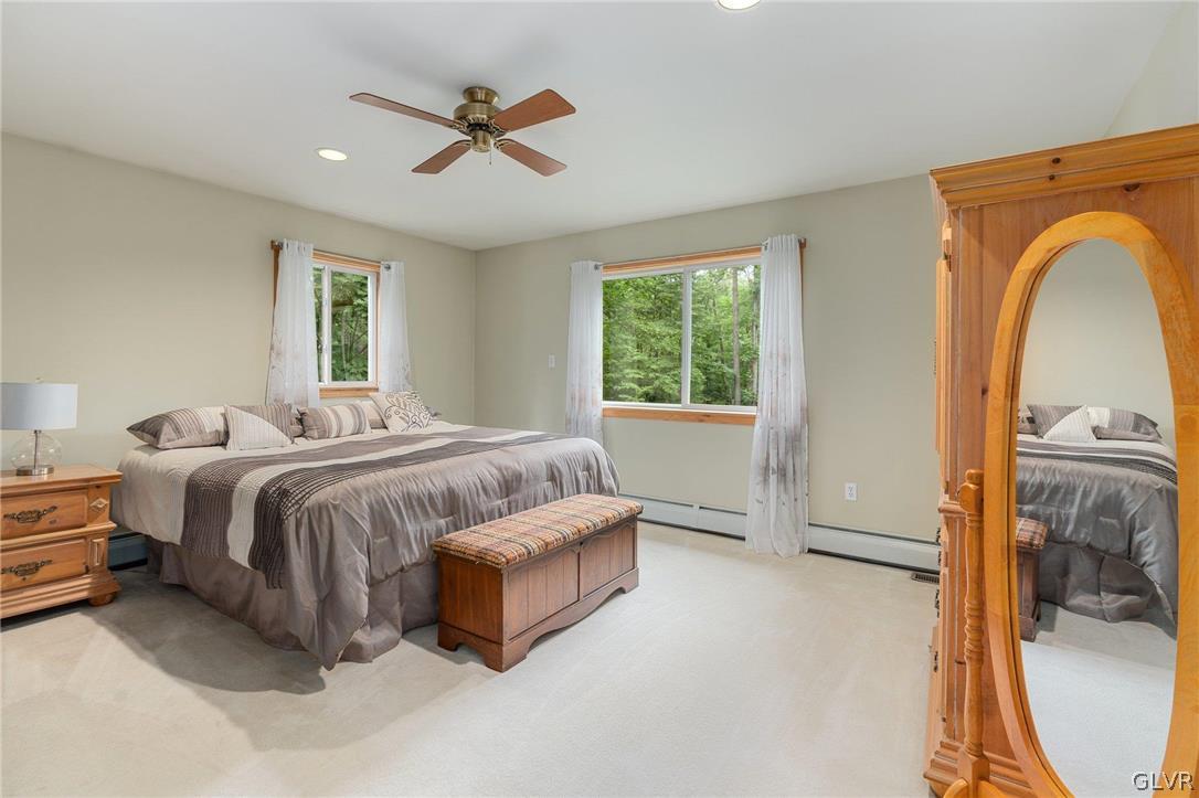3220 Winding Road Kintnersville, PA 18930 - Photo 42 of 50 a spacious bedroom with a bed a couch and a window