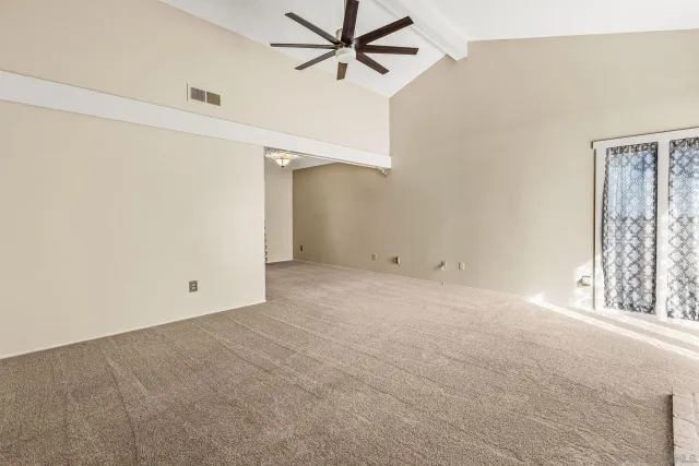 an empty room with windows and fan