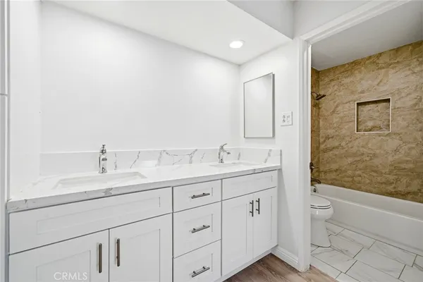 a bathroom with a granite countertop sink mirror and toilet