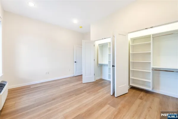 a view of an empty room with closet and a window