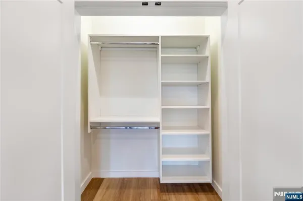 a view of walk in closet with empty racks