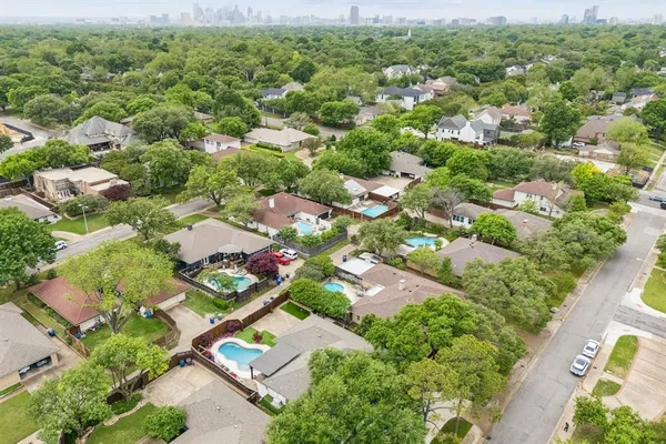 an aerial view of residential houses with outdoor space and trees