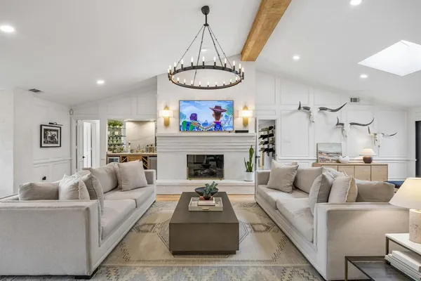 a living room with furniture a fireplace and a chandelier