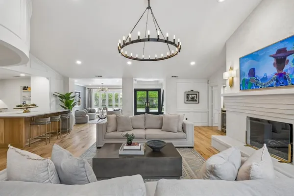 a living room with furniture a fireplace and a chandelier