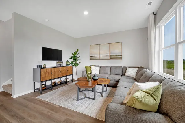 a living room with furniture flat screen tv and a window
