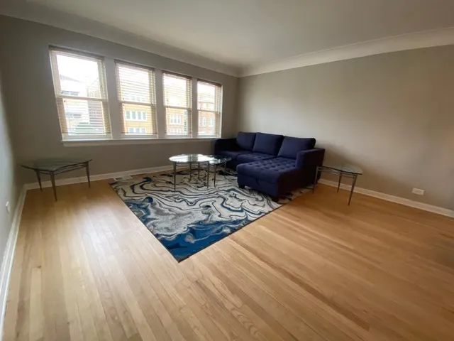 a living room with a couch wooden floor and a table