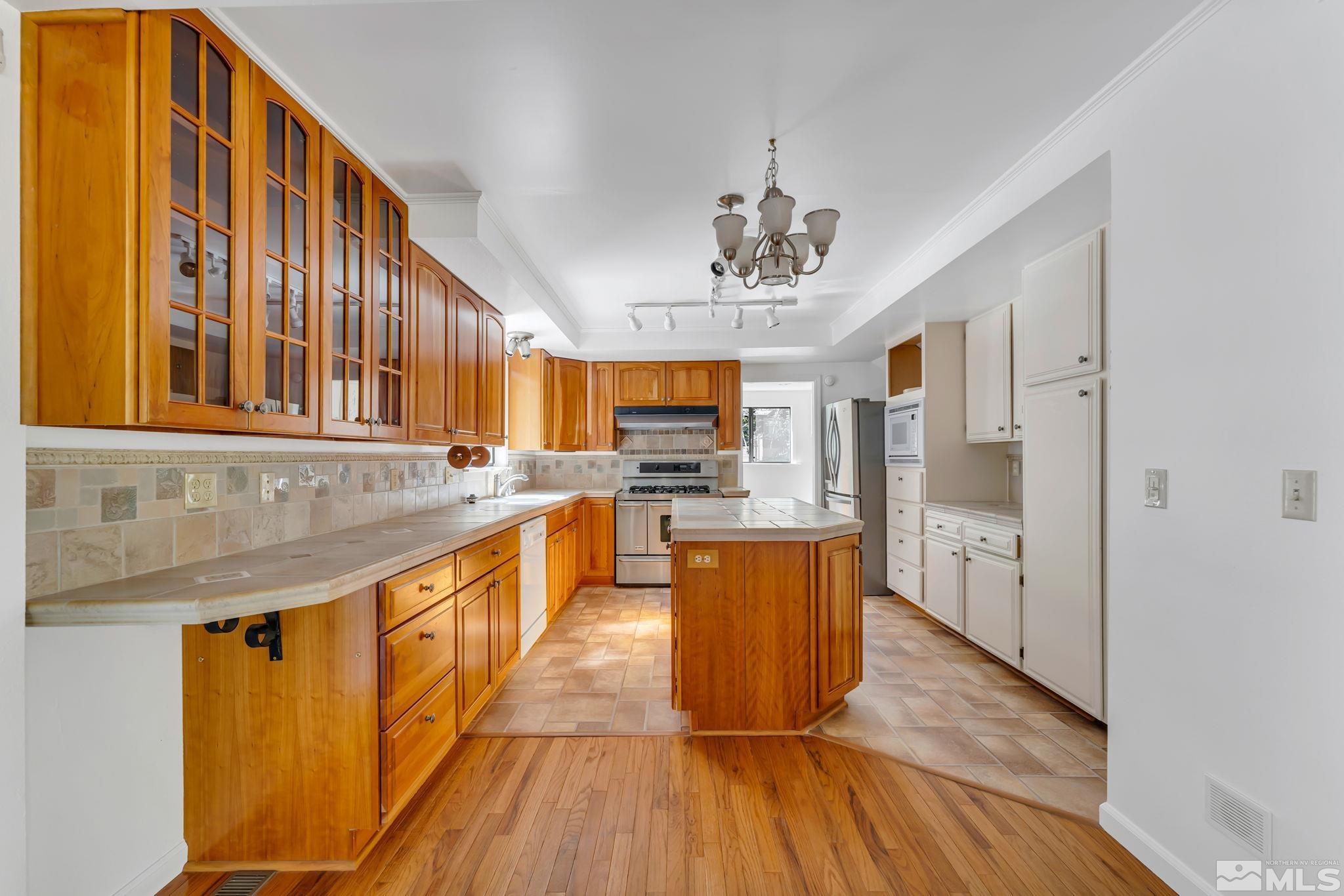 213 Chimney Rock Road Stateline, NV 89449 - Photo 11 of 37 a large kitchen with stainless steel appliances granite countertop a refrigerator a oven a stove and a wooden floors