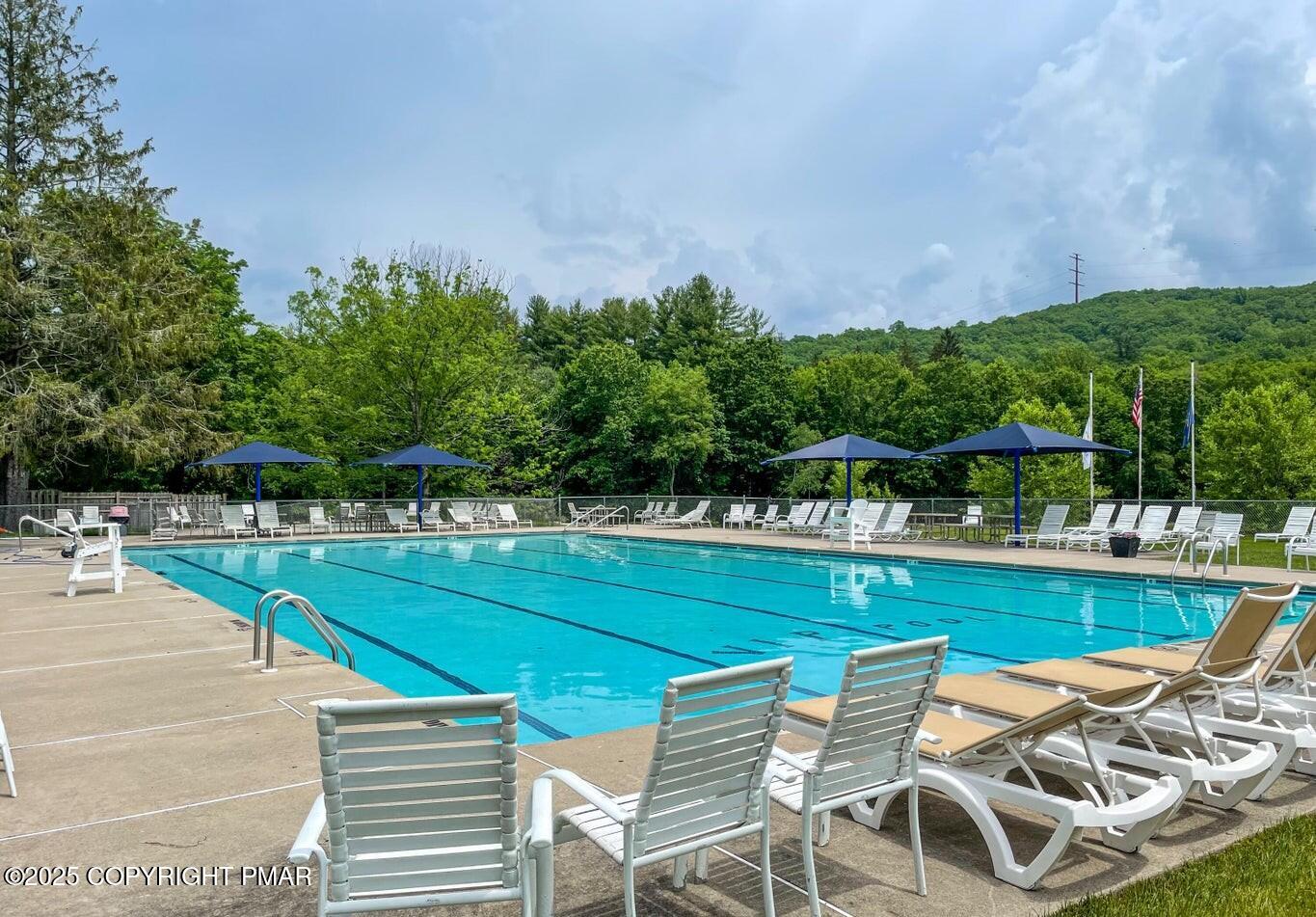 125 Edinburgh Road Bushkill, PA 18324 - Photo 55 of 64 a view of a swimming pool with lawn chairs under an umbrella