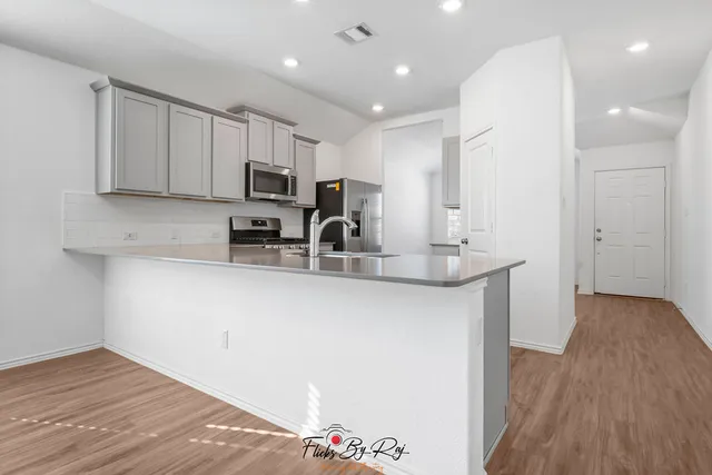 a kitchen with stainless steel appliances granite countertop a sink refrigerator and microwave