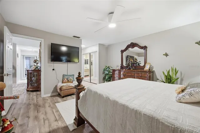 a bedroom with a bed a flat screen tv and a chandelier
