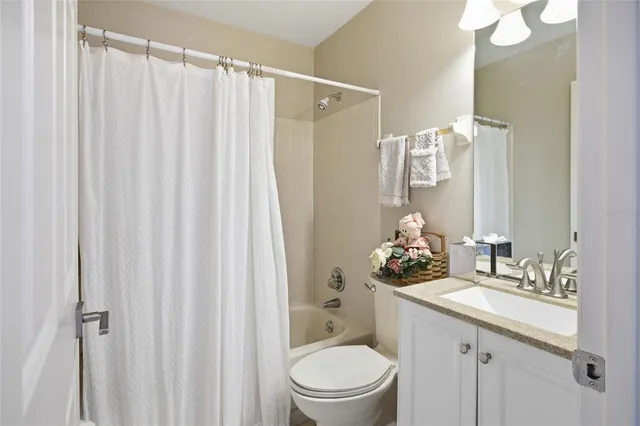 a bathroom with a sink a toilet and shower curtain