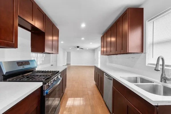 a kitchen with a sink a stove and cabinets