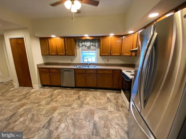 a kitchen with stainless steel appliances granite countertop a refrigerator and a sink
