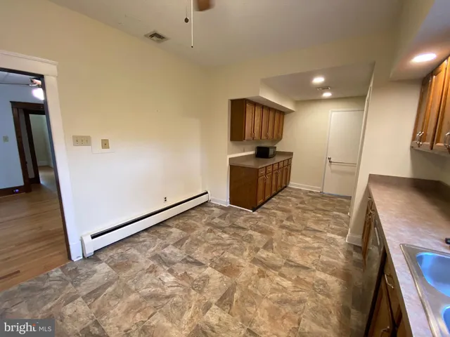 a large kitchen with a refrigerator and a stove