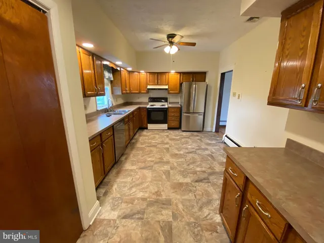 a kitchen with granite countertop a sink stove and refrigerator