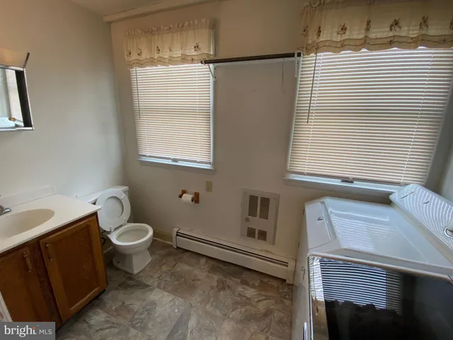a bathroom with a toilet sink and mirror