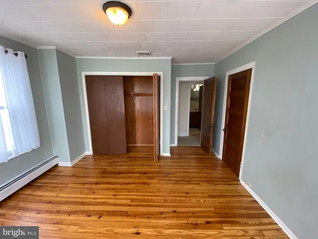 a view of a livingroom with wooden floor and closet