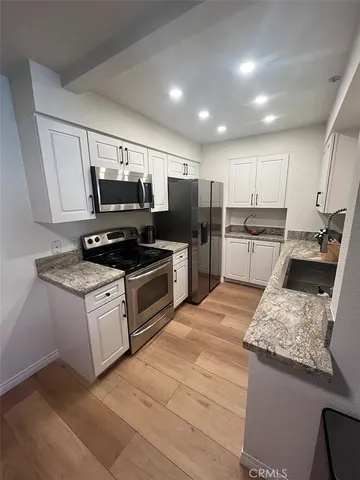 a kitchen with granite countertop stainless steel appliances and wooden cabinets