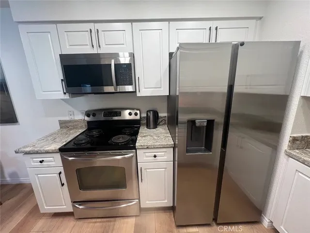 a kitchen with stainless steel appliances a refrigerator stove and microwave