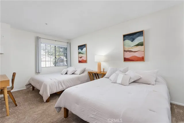 a bedroom with two beds and a window