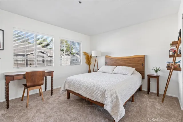 a large bed sitting in a bedroom next to a window with chair and table