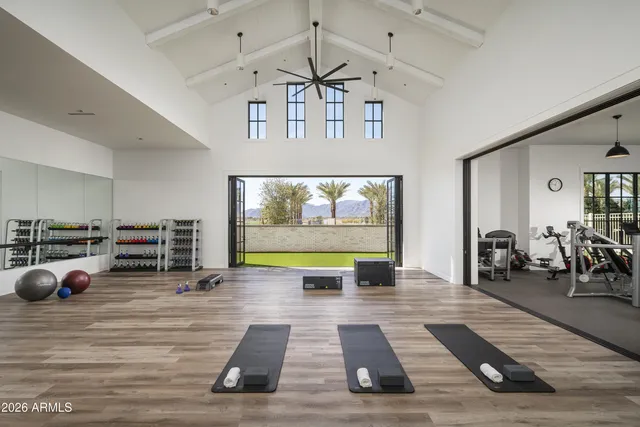a large white kitchen with stainless steel appliances kitchen island granite countertop a stove and a refrigerator