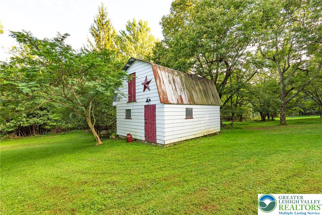 1114 Fox Gap Road Bangor, PA 18013 - Photo 58 of 63 Mature trees frame a charming outbuilding nestled on the grassy property grounds.