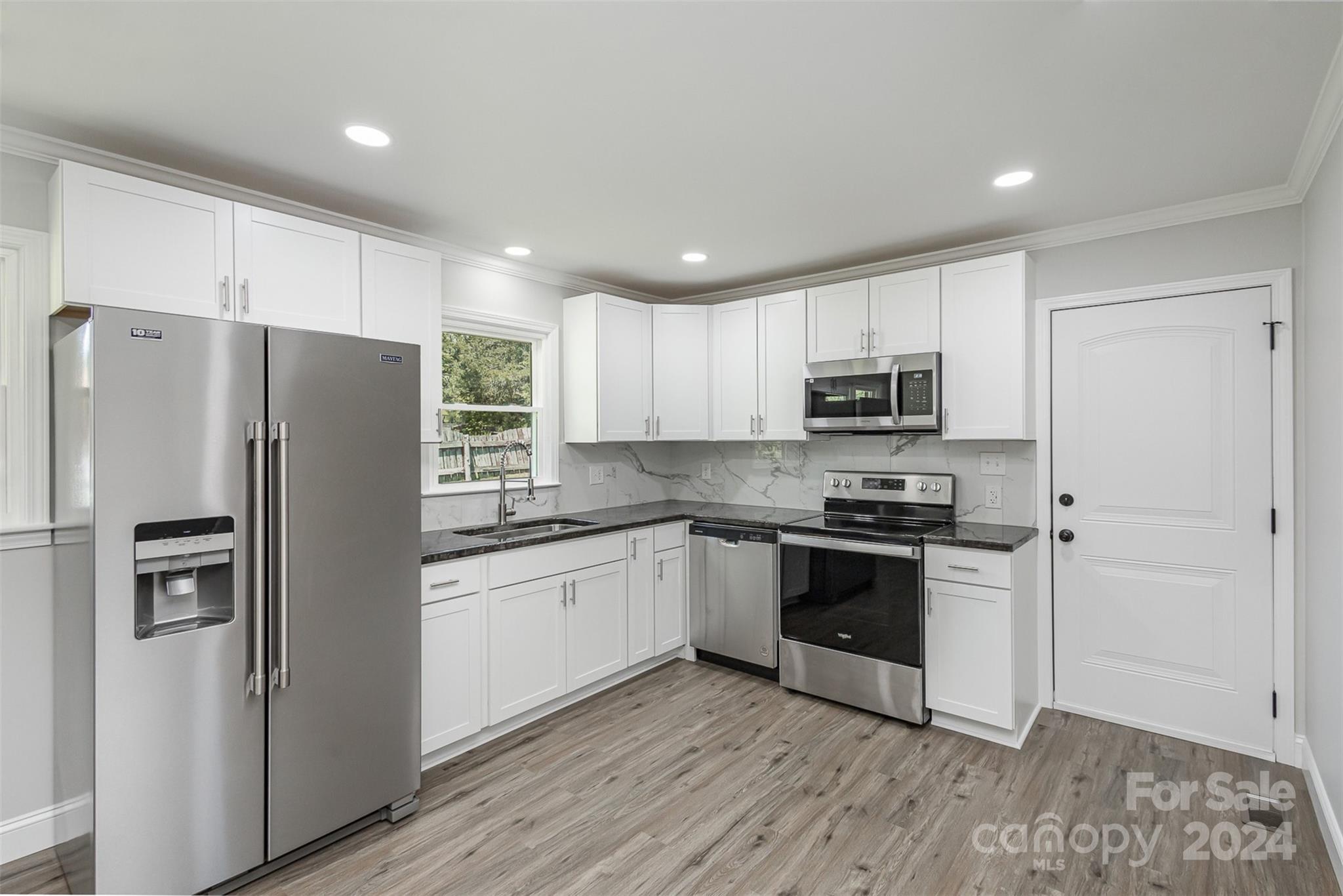 613 Unique Street Chester, SC 29706 - Photo 11 of 27 a kitchen with stainless steel appliances granite countertop a refrigerator and a stove top oven