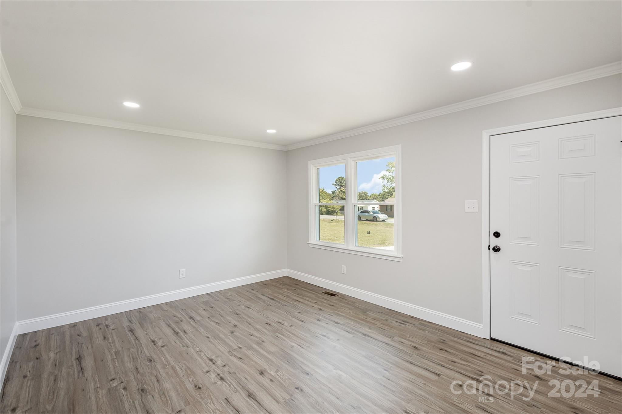 613 Unique Street Chester, SC 29706 - Photo 8 of 27 an empty room with wooden floor and window