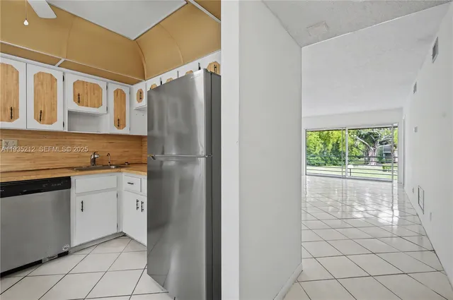 a kitchen with granite countertop a refrigerator and a sink
