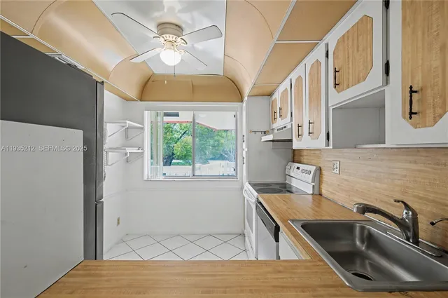 a kitchen with a sink a counter top space cabinets and stainless steel appliances