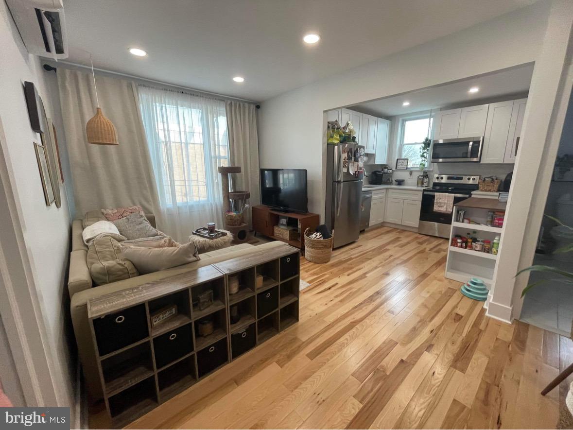 1501 South 12th Street, Unit 3F Philadelphia, PA 19147 - Photo 18 of 23 a living room with stainless steel appliances furniture a flat screen tv and kitchen view