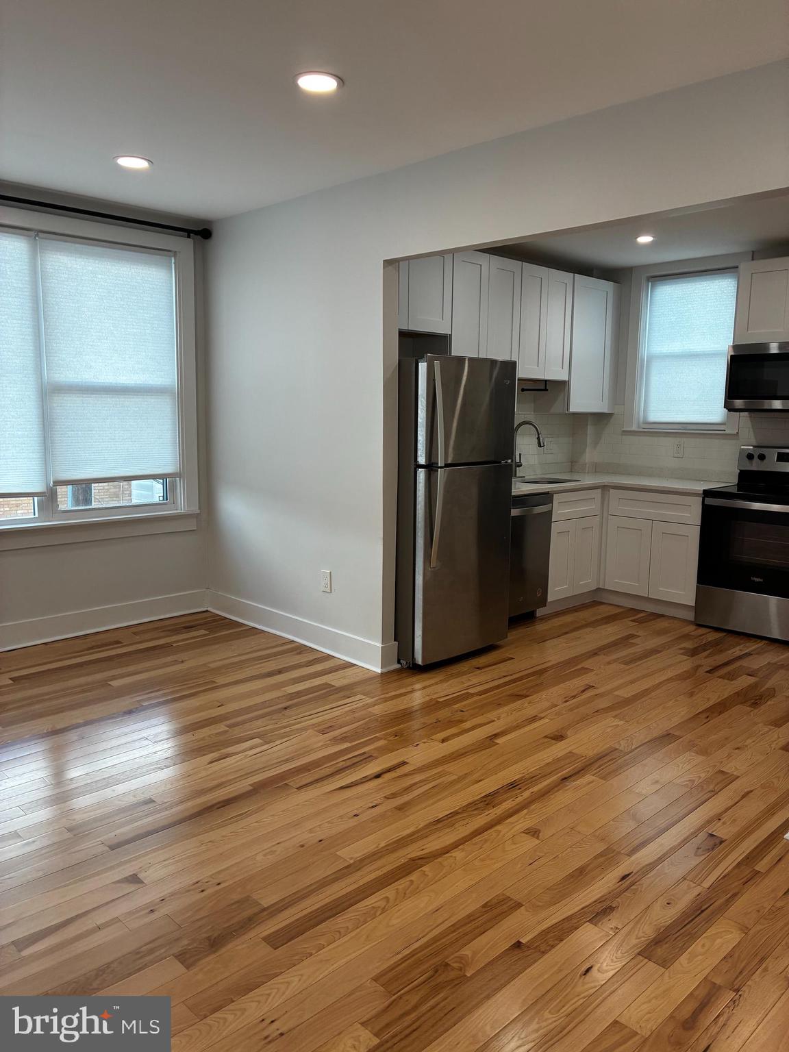 1501 South 12th Street, Unit 3F Philadelphia, PA 19147 - Photo 3 of 23 a kitchen with stainless steel appliances wooden floor and a refrigerator