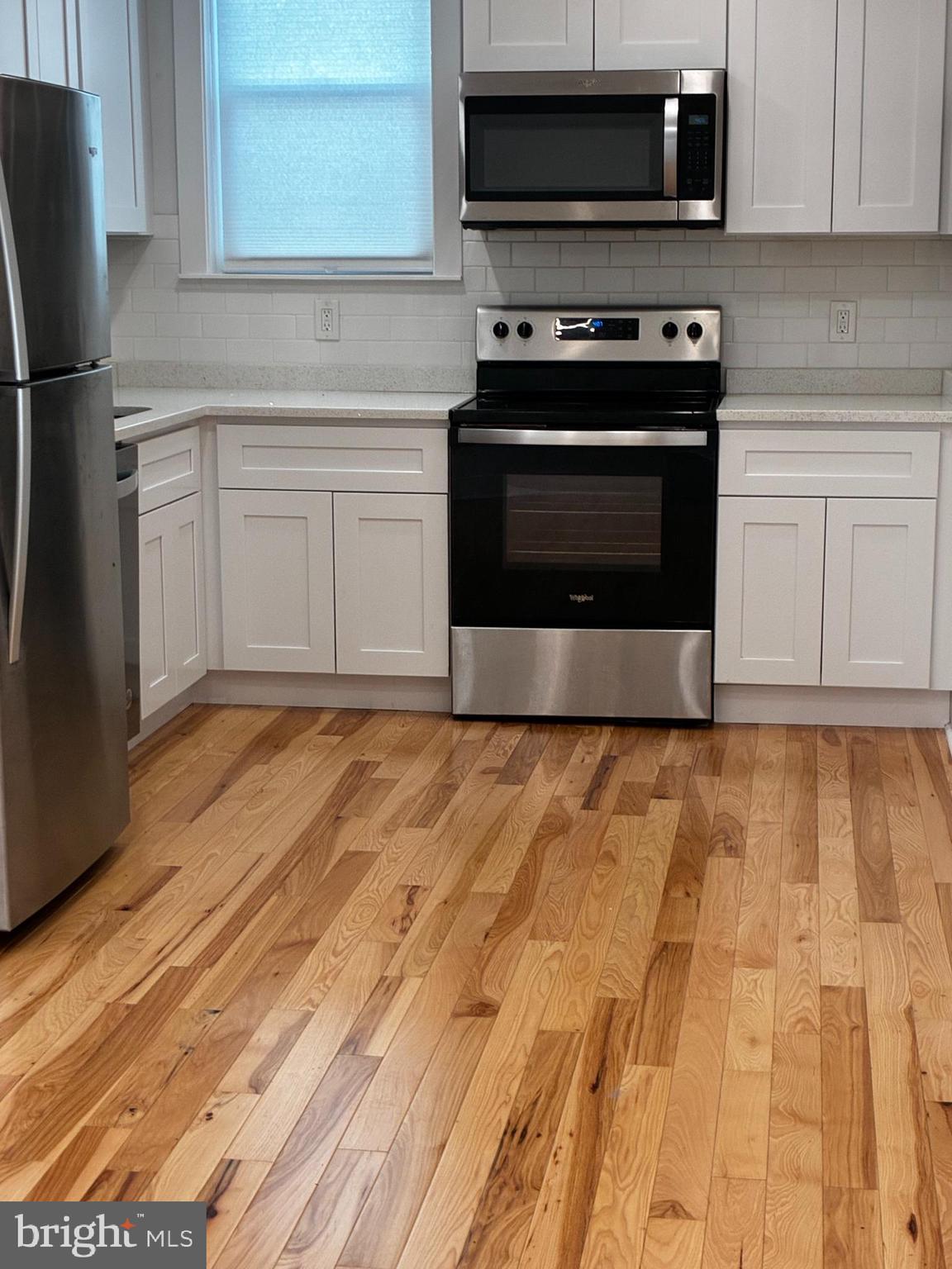 1501 South 12th Street, Unit 3F Philadelphia, PA 19147 - Photo 5 of 23 a kitchen with granite countertop a stove and a microwave