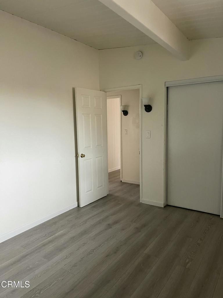712 South G Street, Unit E Oxnard, CA 93030 - Photo 13 of 14 an empty room with wooden floor and windows