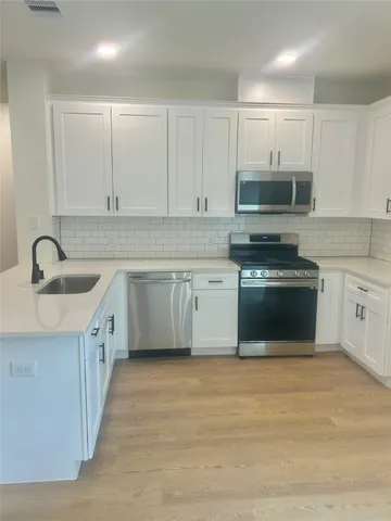 a kitchen with granite countertop white cabinets and white stainless steel appliances