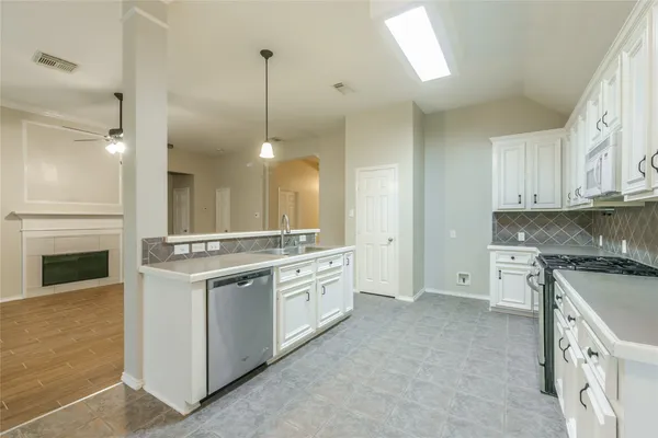a large kitchen with stainless steel appliances granite countertop a stove and a sink