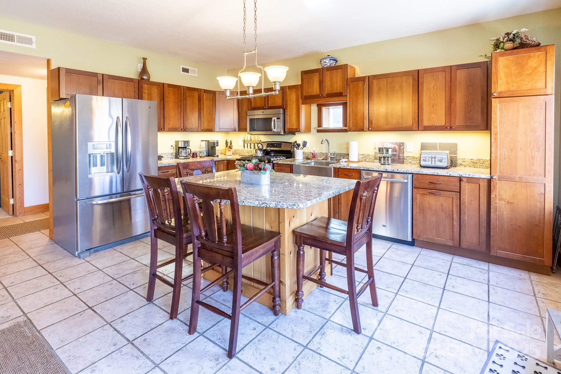 283 Walnut Cv Ridge Bryson City, NC 28713 - Photo 30 of 42 a kitchen with stainless steel appliances a dining table chairs and granite counter tops