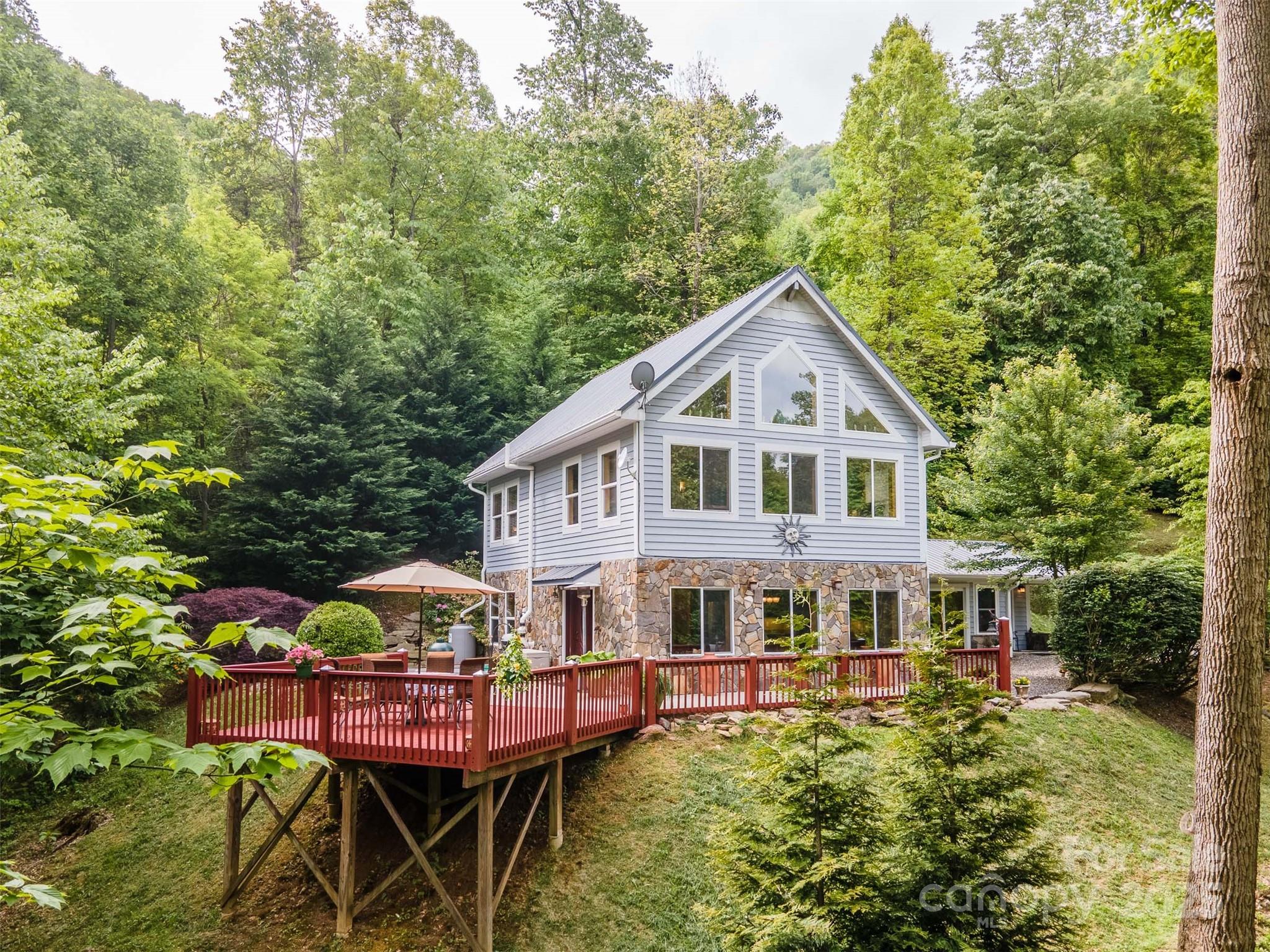 283 Walnut Cv Ridge Bryson City, NC 28713 - Photo 5 of 42 a front view of a house with a yard table and chairs