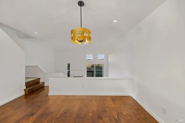 a view of a room with wooden floor and windows