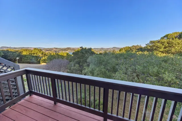 a balcony with wooden floor and city view