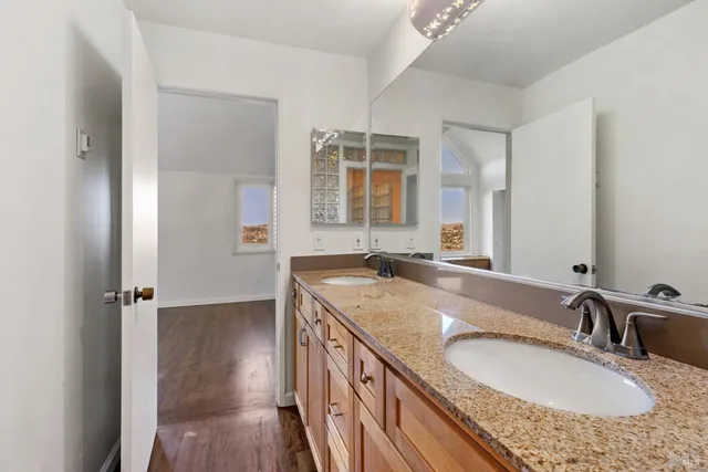 a bathroom with a granite countertop sink a mirror and shower