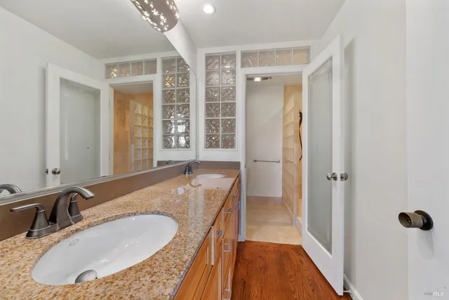 a bathroom with a granite countertop sink and a mirror