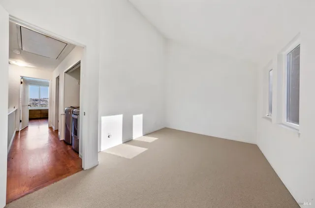 a view of a hallway with wooden floor and a living room