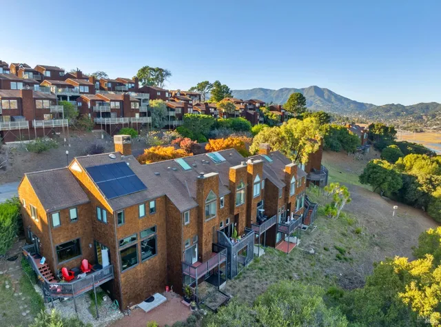 a front view of a multi story residential apartment building with yard and outdoor seating