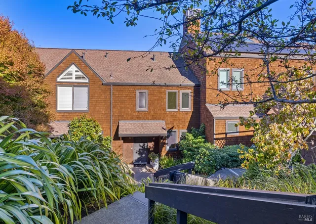 front view of house with a bench and potted plants