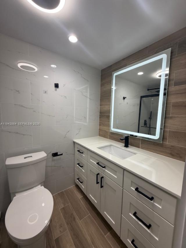 3208 Colony Club Road, Unit 2 Pompano Beach, FL 33062 - Photo 14 of 18 a bathroom with a toilet a sink and mirror