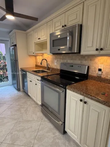 a kitchen with stainless steel appliances granite countertop a sink stove and microwave