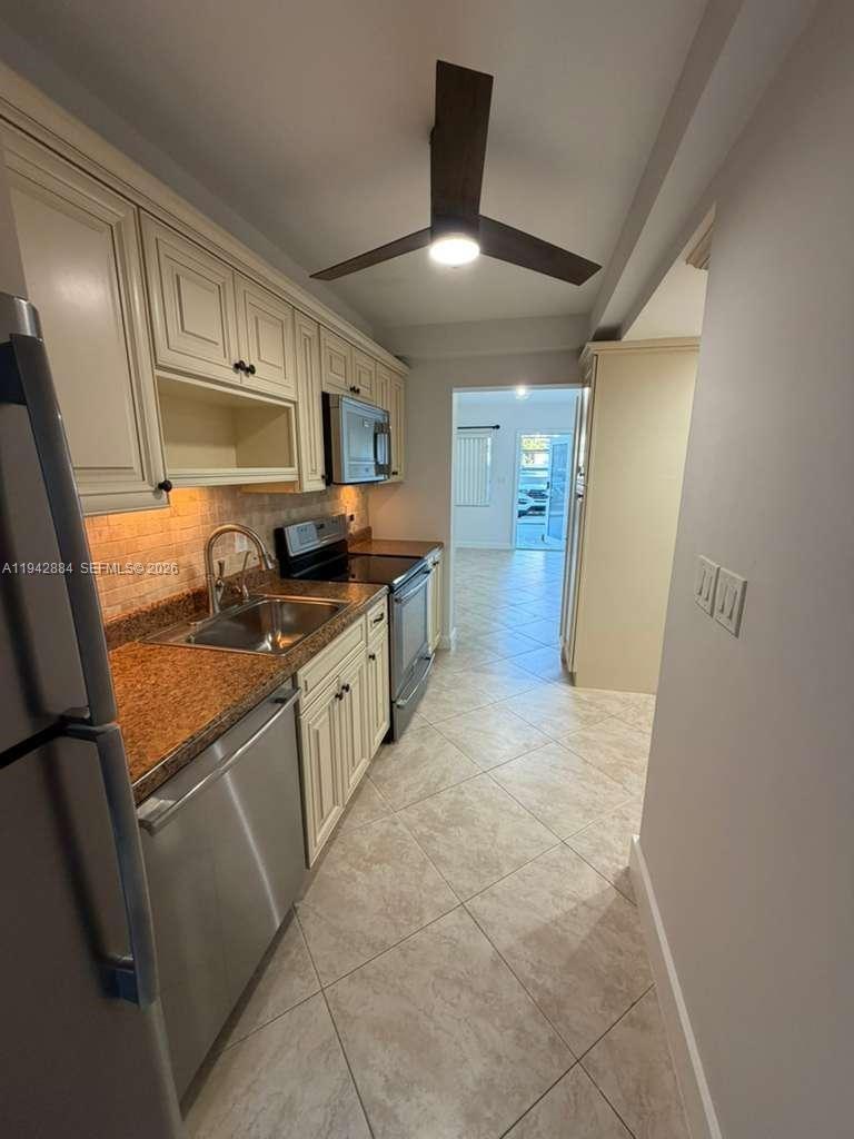 3208 Colony Club Road, Unit 2 Pompano Beach, FL 33062 - Photo 4 of 18 a large kitchen with stainless steel appliances a sink and cabinets